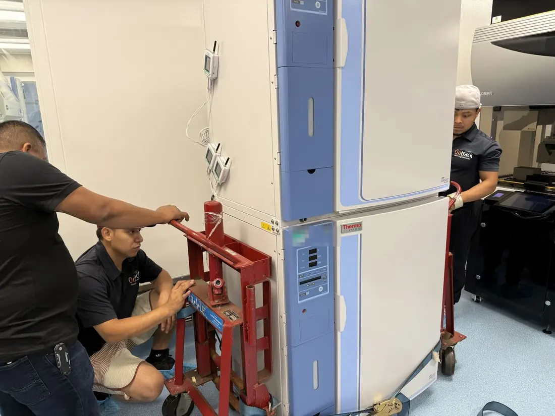 Ontrack Moving crew moving a stacked pair of laboratory incubators with a lift jack during a Bay Area biotech laboratory relocation