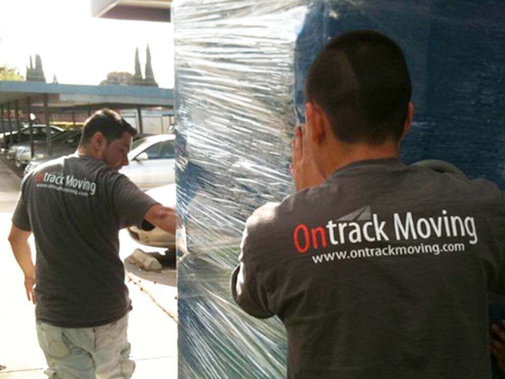 Ontrack Moving team carrying large furniture piece
